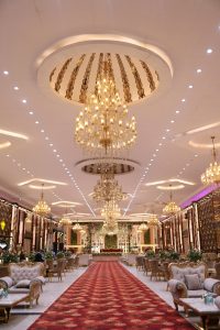 Opulent wedding banquet hall featuring grand chandeliers and elegant decor.